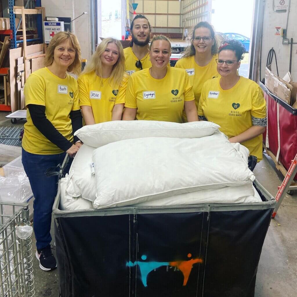 Volunteer group posing by pillows.