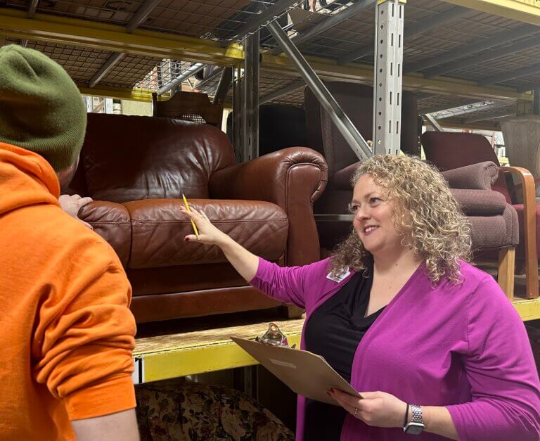 Bridging staff assisting client to pick out furniture